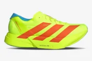 Adidas Adizero Adios Pro 4 running shoe in neon yellow and orange, side profile view. - SKU JQ1571
