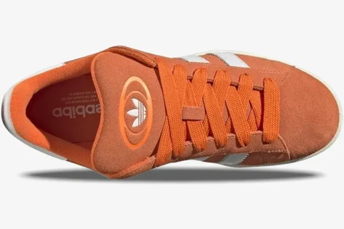 Top-down view of Adidas Campus 00s sneakers in amber tint orange with white stripes and thick laces. - SKU ID1436