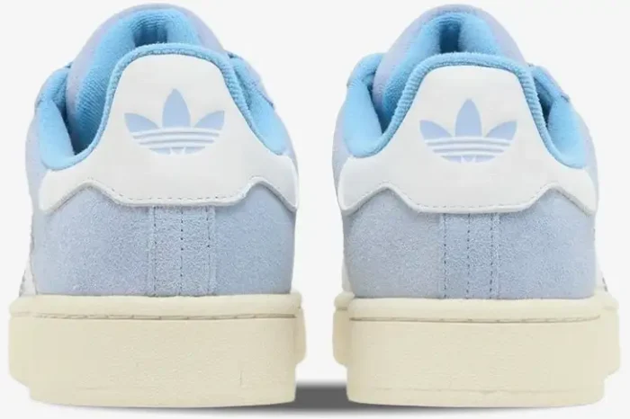 Rear view of Adidas Campus 00s sneakers in ambient sky blue suede with white heel tabs and cream soles. - SKU GY9473