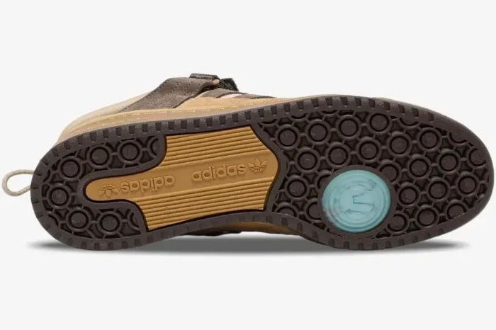 Outsole view of the brown and tan Adidas Forum Buckle Low x Bad Bunny Café sneaker with a blue eye logo. - SKU GW0264