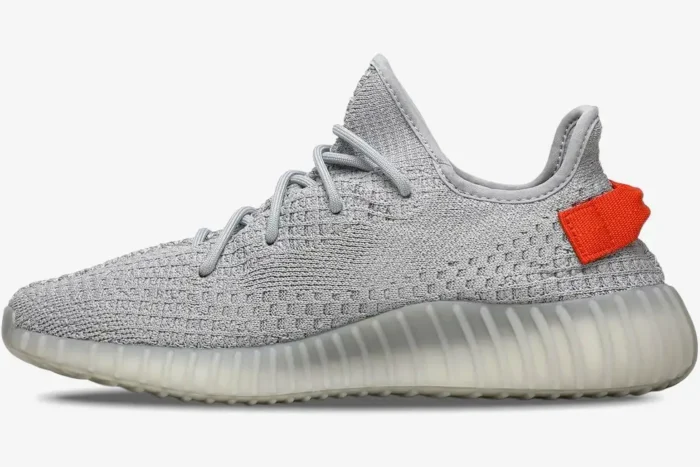 Side view of Adidas Yeezy 350 V2 Tail Light in grey with a bright orange heel tab. - SKU FX9017