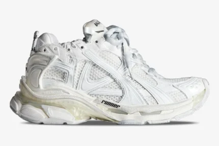 Side view of white Balenciaga Runner sneakers featuring a chunky, multi-layered mesh and nylon design. - SKU 772774W3RMU9000