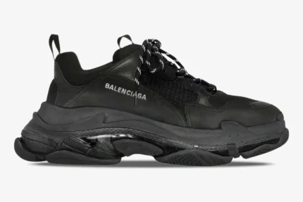 Side profile of a Balenciaga Triple S Clear Sole sneaker in black with a chunky translucent sole. - SKU 541624W2FB11000