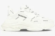 White Balenciaga Triple S sneaker with black all-over logo print, side profile view on a white background. - SKU 536737W2FA19010
