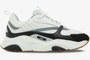 Side view of a Dior B22 luxury chunky sneaker in white and black with a gum sole. - SKU 3SN231YKB_H968