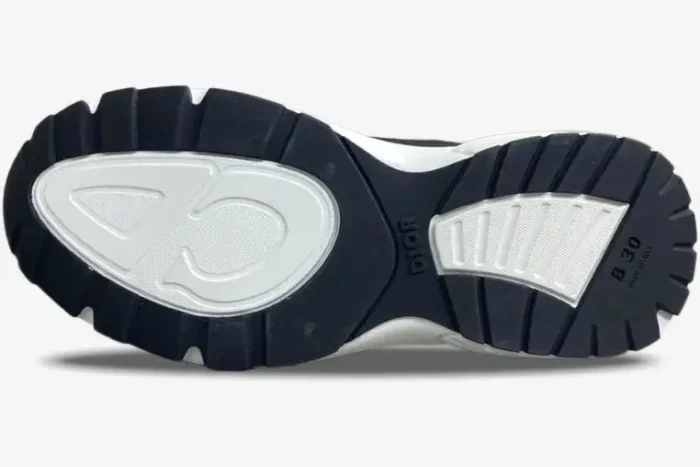 Bottom sole of a black and white Dior B30 sneaker showing the tread pattern and brand logos. - SKU 3SN279ZRB_H865