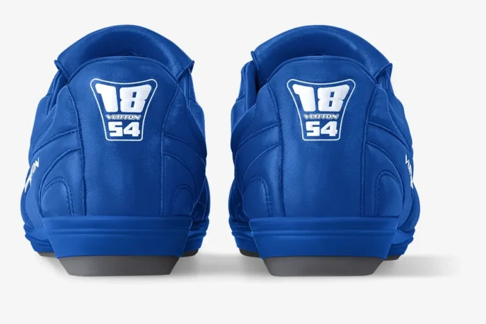 Rear view of blue Louis Vuitton Footprint Soccer Shoes featuring the 18 Vuitton 54 logo on the heels.
