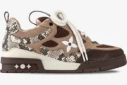 Side view of Louis Vuitton Skate Sneaker in brown snakeskin and monogram mesh with thick white laces.