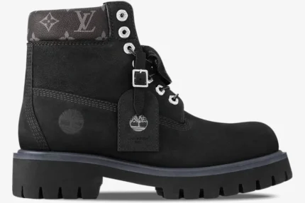 Side profile of a black Louis Vuitton x Timberland 6-inch ankle boot with monogram collar and silver hardware. - SKU 1AD75A