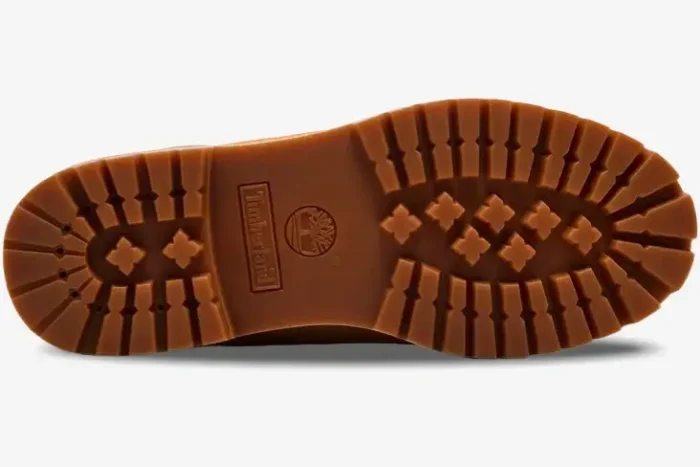 Bottom view of the Louis Vuitton x Timberland 6-Inch Ankle Boot in tan, showing the rubber lug sole and logo details. - SKU 1AD72X