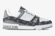 Side view of the Louis Vuitton Trainer featuring grey monogram denim and white pebbled leather. - SKU 1A9Z7C