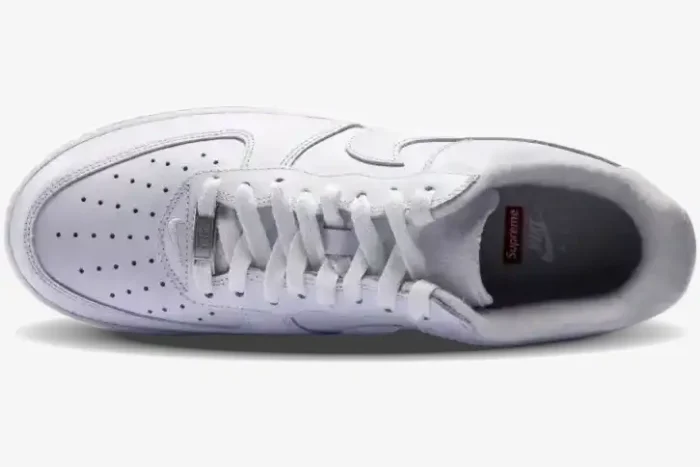 Top-down view of a white Nike Air Force 1 Low x Supreme sneaker showing laces and branded insole. - SKU CU9225-100
