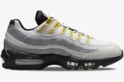 Side profile of Nike Air Max 95 Tour sneakers in white, grey, and yellow with visible air units. - SKU 609048-105