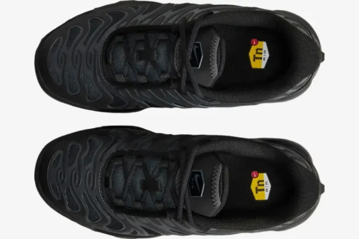 Top-down view of Nike Air Max Plus Drift GS Triple Black sneakers with signature Tn Air logos on the insoles. - SKU FV5921-002