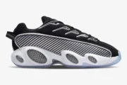 Side view of Nike NOCTA Glide sneakers in black and white with carbon fiber patterns and a thick white midsole. - SKU DM0879-001