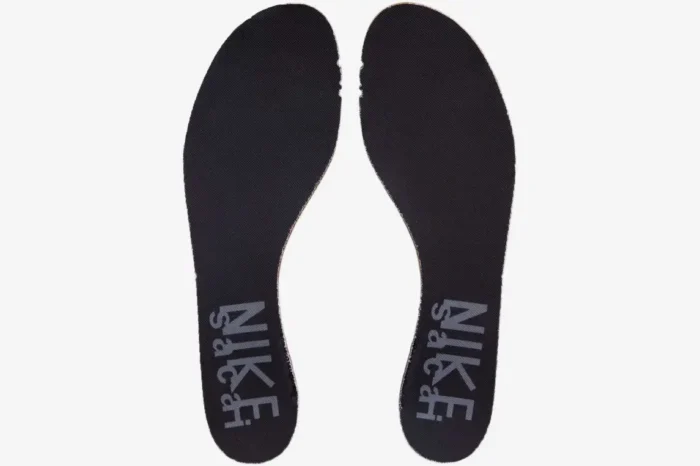 Top-down view of black Nike VaporWaffle x Sacai insoles featuring grey dual-branded logos on the heel area. - SKU DD1875-001