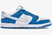 Nike SB Dunk Low x Born x Raised sneaker in blue and white, side profile view with iridescent swoosh. - SKU FN7819-400