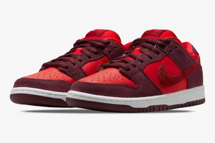 Nike SB Dunk Low Cherry sneakers in red and burgundy suede, shown from a three-quarter front angle. - SKU DM0807-600