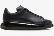 Side profile of Alexander McQueen Oversized sneakers in black with a transparent sole. - SKU 604232-WHX98-1000