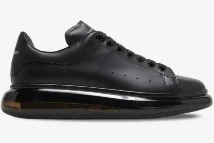 Side profile of Alexander McQueen Oversized sneakers in black with a transparent sole. - SKU 604232-WHX98-1000