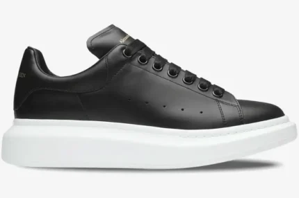 Alexander McQueen Oversized Sneaker in black leather with a thick white sole, side profile view. - SKU 553680WHGP51000