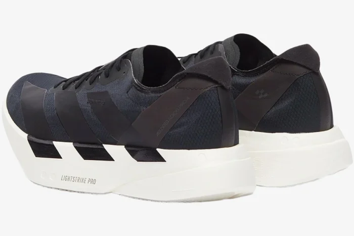Rear perspective of Adidas Adizero Adios Pro 4 running shoes in black and white with Lightstrike Pro foam. - SKU JR6369
