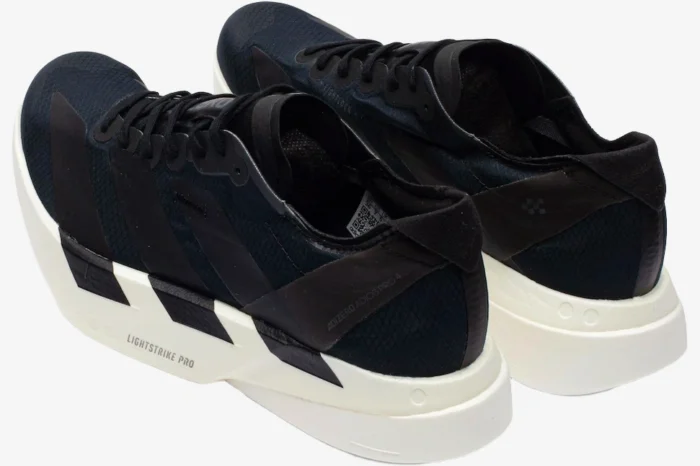 Rear-side view of black and white Adidas Adizero Adios Pro 4 running shoes with thick white midsoles. - SKU JR6369