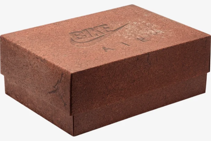 Three-quarter view of the reddish-brown textured shoebox for Air Jordan 4 x Nigel Sylvester Bike Air. - SKU HF4340-800
