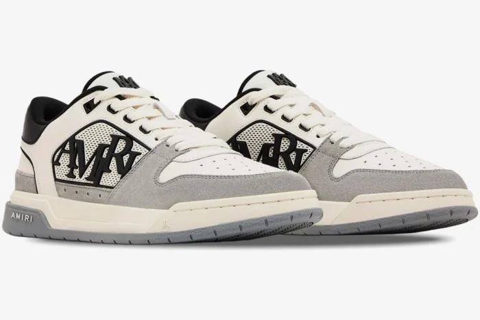 Amiri Classic Low luxury sneakers in white, grey, and black, shown from a side three-quarter angle. - SKU AMFOSR1067-001