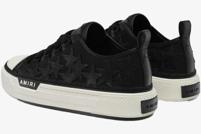 Rear three-quarter view of black Amiri Stars Court sneakers with leather star patches and white platform soles. - SKU AMFOSR1178-083