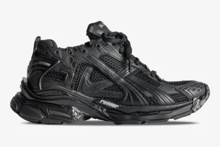 Side profile of a Balenciaga Runner All Black Distressed Sneaker with mesh panels and chunky sole. - SKU 772774W3RBT1000