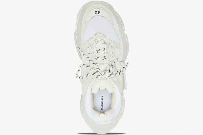 Top-down view of a white Balenciaga Triple S sneaker featuring a clear sole and black-and-white laces. - SKU 544351W2FB19000