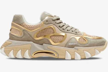 Side profile of a Balmain B-East B3V27 sneaker in beige and metallic gold with a chunky, claw-like sole. - SKU B3V27