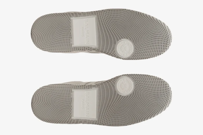 Bottom view of off-white Balmain Swan trainers showing the textured rubber soles and logo details. - SKU FM1VI360LWSC