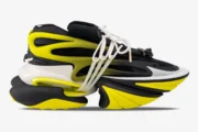 Side view of Balmain Unicorn low-top sneakers in black and yellow with a chunky futuristic sole. - SKU YM0VJ309KNET