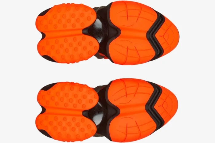 Bottom view of Balmain Unicorn Low-Top sneakers in orange and black showing the textured rubber outsoles. - SKU YM1VJ309KNCA