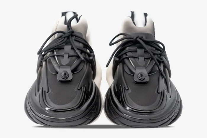 Front view of Balmain Unicorn Low Top sneakers in white and black gradient with lion head detail. - SKU YM0VJ309KNED-GAB