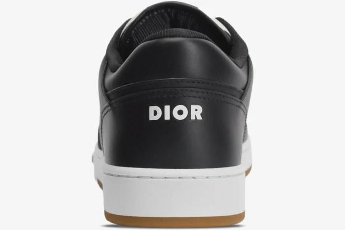 Rear view of a black Dior B27 low-top sneaker featuring a white logo on the heel and white midsole. - SKU 3SN272ZIR_H965