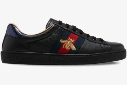 Side view of Gucci Ace Bee black leather sneakers with gold bee embroidery and web stripe. - SKU 42944602JP01284