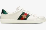 Side view of white Gucci Ace leather sneakers featuring a gold embroidered bee on a green and red web stripe. - SKU 42944602JP09064