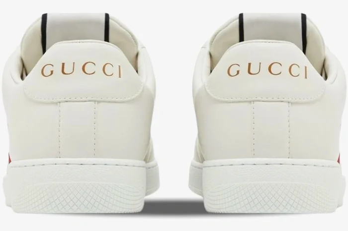 Rear view of white Gucci Ace leather sneakers with gold logo on heel tabs. - SKU 798785AADU09094