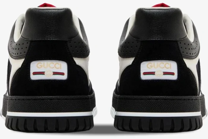 Rear view of black and white Gucci Re-Web sneakers showing the logo patch and textured soles. - SKU 787476AADHW1077