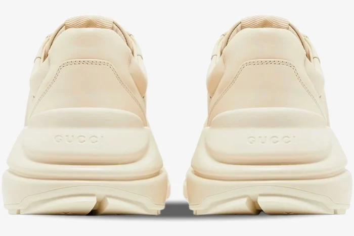 Rear view of ivory Gucci Rhyton sneakers showing the chunky sole and embossed Gucci logo on the heel. - SKU 757857UPG709567