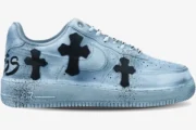 Side profile of a custom Nike Air Force 1 in metallic silver with black Chrome Hearts cross patches.