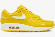 Nike Air Max 1 x Supreme limited edition yellow leather sneaker, side profile view with white Swoosh and midsole. - SKU HF8813-700