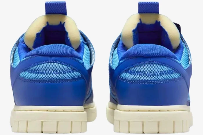 Rear view of Nike Dunk Low Remastered Jumbo Blue sneakers featuring exposed foam tongues and cream soles. - SKU DV0821-400
