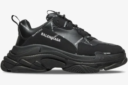 Side view of Balenciaga Triple S Sneaker in black with allover white logo print and chunky layered sole.