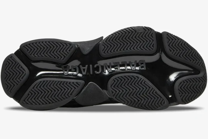 Bottom view of black Balenciaga Triple S Sneaker with embossed logo and textured rubber outsole.