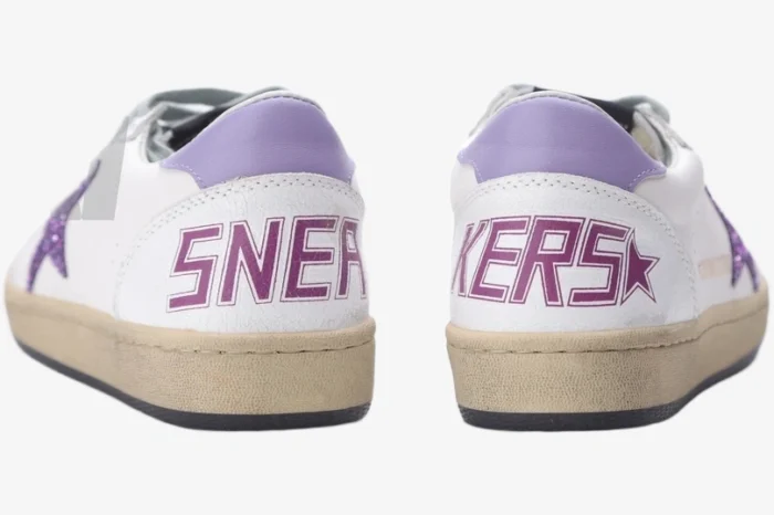 Rear view of Golden Goose Ball Star white leather sneakers with purple glitter accents and SNEAKERS text on heels. - SKU GWF00117.F002544.10915