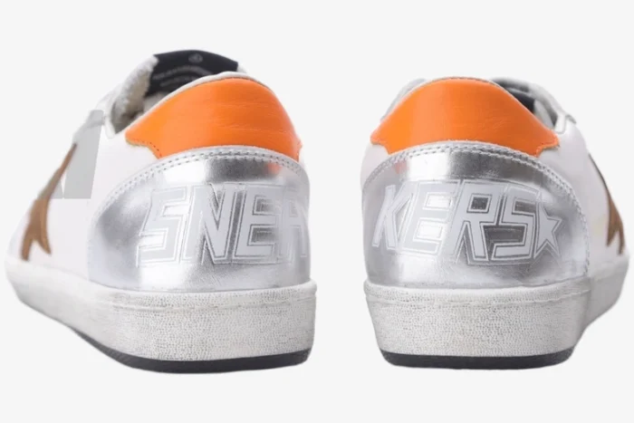 Rear view of Golden Goose Ball Star white and silver sneakers with orange heel tabs. - SKU GMF00117.F002585.10912